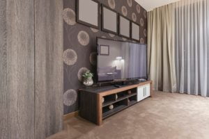Using paint and stencils on the feature wall can help a tv become part of your home decor.